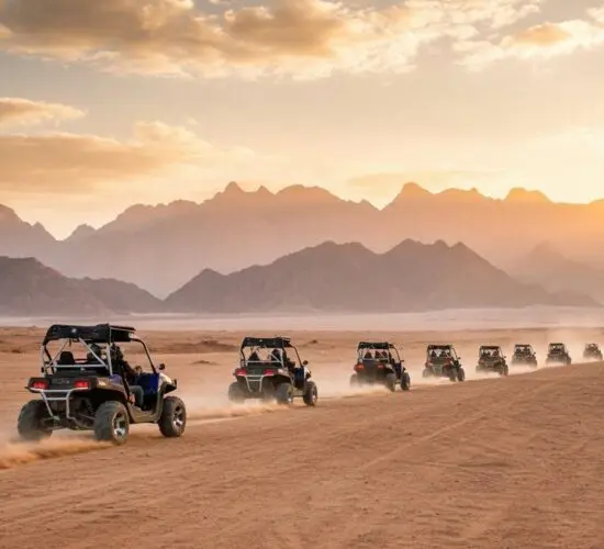 4-seater buggy tearing through the golden desert sands of Sharm El Sheikh, kicking up dust against rugged Sinai mountains