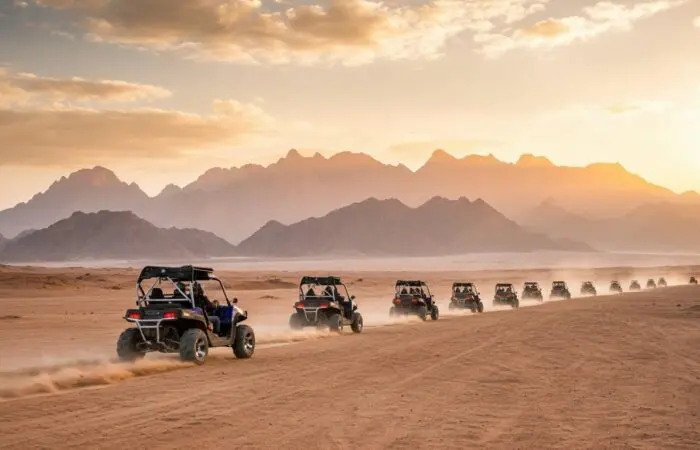 4-seater buggy tearing through the golden desert sands of Sharm El Sheikh, kicking up dust against rugged Sinai mountains
