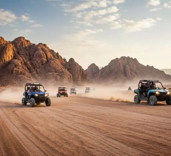 Double-seater buggy kicking up sand while racing across Sharm El Sheikh's desert at sunset, Sinai mountains glowing behind