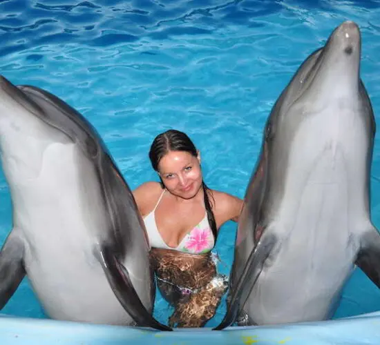 girl hugging two dolphins at sharm blue excursions