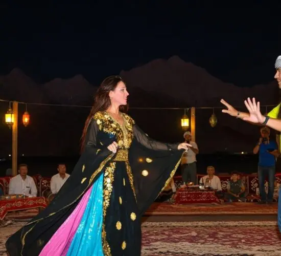 Traditional Bedouin tent dinner with colorful lights and live show during Sharm El Sheikh super safari at night.