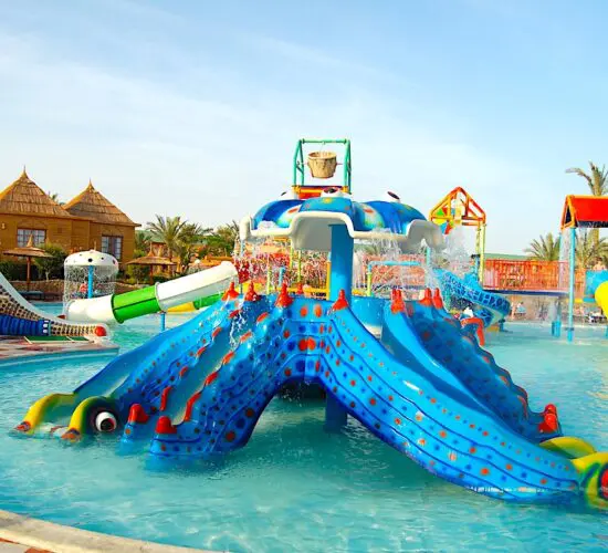 Sparkling kids pool and rides at Sharm El Sheikh’s vibrant water park, surrounded by colourful slides and palm trees.