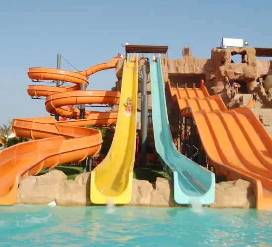 Exciting family fun on the colorful twisting water slides at Sharm El Sheikh’s tropical-themed water park, surrounded by palm trees and bright sunshine.