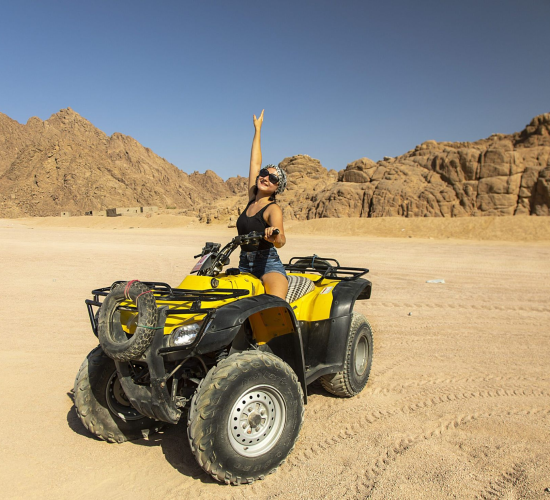 A happy girl riding a quad bike
