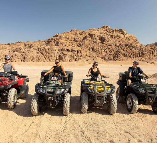 A group smiling for the picture, quad biking in Sharm EL Sheikh desert
